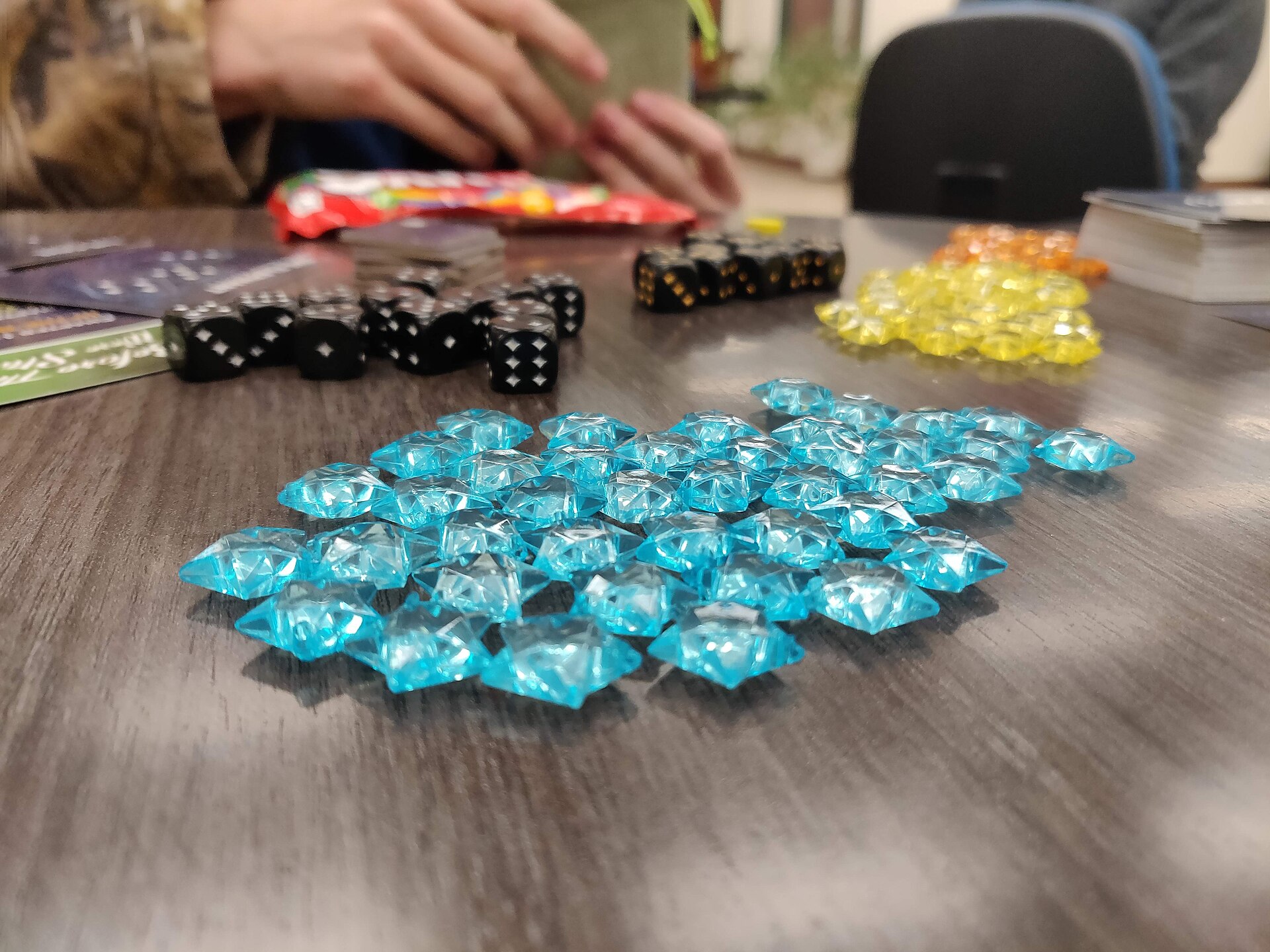 Dice and colourful board-game pieces on a table during play